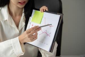Financial presentation. Young woman discussing graphs and tax data on a presentation file. photo