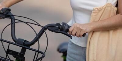 Close-up of a woman's hand gripping a bicycle handlebar, promoting sustainable transport. photo
