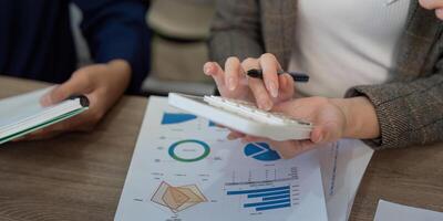 Professional analyzing data with a calculator during a team meeting. photo