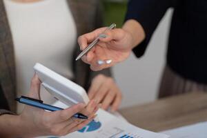 Business professionals discussing financial data while using a tablet and pen in a meeting. photo