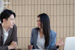 Professional collaboration. Two business professionals engaging in a discussion while analyzing project plans and strategies. photo
