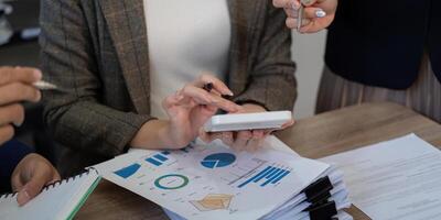 Collaborative teamwork in a business meeting analyzing financial data with charts and reports. photo