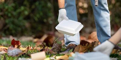 Volunteer collecting trash in a park during an eco-friendly initiative photo