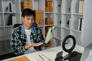 Young man presenting a product while working in a modern shipping workspace. photo