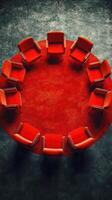 Circular arrangement of red chairs on a vibrant red carpet in an indoor setting photo