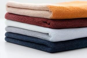 Stack of colorful towels forming a gradient on white background photo