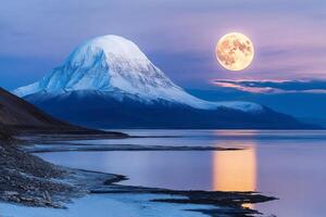 Full moon rising over snowy mountain reflecting in calm lake at twilight photo