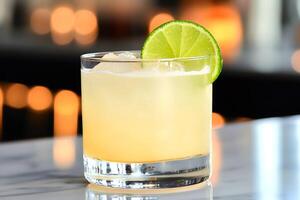 Refreshing cocktail with lime and ice cubes on bar counter with blurred lights in background photo