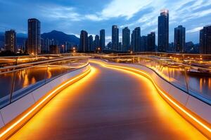 Illuminated pedestrian bridge crossing river in modern city at dusk photo