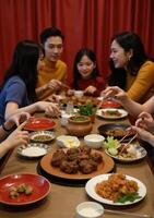 A group of people eating at a table with food photo