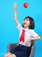 A girl in a school uniform is throwing an apple photo