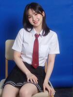 A woman in a school uniform sitting on a chair photo