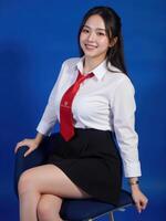 A woman in a school uniform sitting on a chair photo