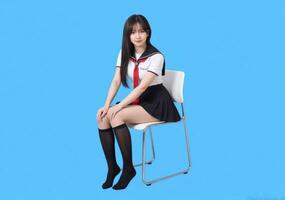 A girl in a school uniform sitting on a chair photo