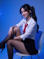 A woman in a school uniform sitting on a chair photo
