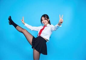 Asian girl in school uniform posing with peace sign photo