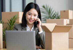 A woman in business attire talking on the phone while sitting in front of boxes photo