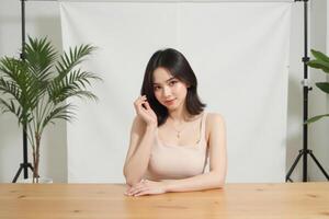 A woman sitting at a table with a phone in front of her photo