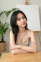 A woman sitting at a table with her arms crossed photo