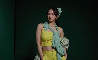 poised woman wears an oversize 2025 futuristic look featuring sharp lines and metallic details, set against a dark green background, photographed from a unique, overhead angle photo