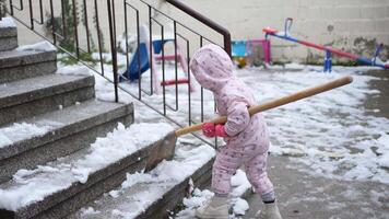 Little one explores winter wonderland while shoveling snow video
