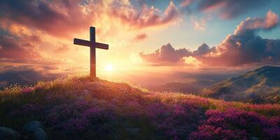Sunset over a hilltop cross with vibrant flowers glowing in the twilight photo