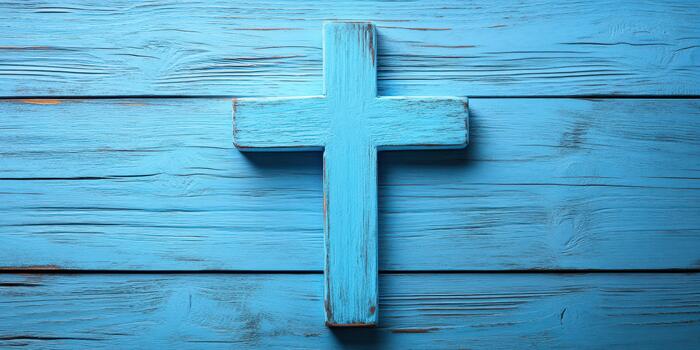 Wooden blue cross displayed on a rustic wooden table conveying a sense of spirituality and reflection photo
