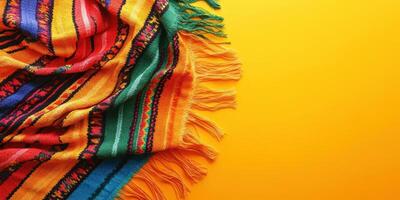 Colorful woven blanket draped on vibrant yellow background showcasing intricate patterns and textures photo