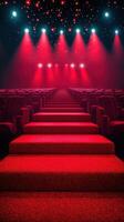 Red carpet leading to a stage with dramatic lighting in a large auditorium at an evening event photo