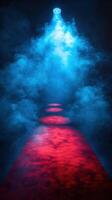 Red carpet path illuminated by blue spotlight with fog effects creating a dramatic atmosphere photo