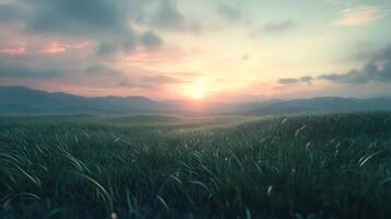 Serene sunset over a lush green field with distant mountains casting shadows as the sky transitions from warm hues to cool tones photo
