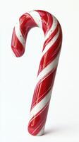 Decorative candy cane stands upright against a plain background showcasing its vibrant red and white stripes during the holiday season photo