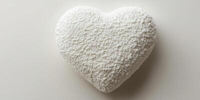White heart-shaped object resting on a plain surface showcasing texture and shape photo