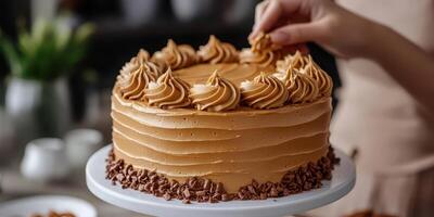 Baker decorates a creamy chocolate cake with swirls of frosting in a cozy kitchen photo