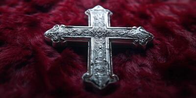Silver cross resting on a crimson velvet background highlighting intricate detailing and craftsmanship photo