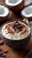 Delicious creamy dessert served in a dark bowl with chocolate and coconut accents in a cozy setting photo