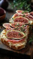Delicious toasted bread topped with fresh figs, ham, and herbs served on a wooden board photo