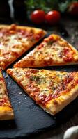 Freshly baked pizza slices with melted cheese and toppings on a black stone plate in a rustic setting photo
