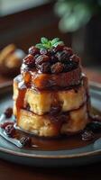 Deliciously stacked dessert with rich caramel sauce and raisins garnished with fresh mint on a rustic wooden table photo