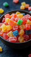 Colorful gummy candies in a black bowl ready to be enjoyed at a party or celebration photo