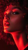 Beautiful woman with curly hair illuminated by red light in a captivating portrait taken indoors during evening hours photo
