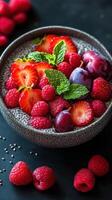 Fresh fruit bowl with chia pudding and mint displayed on dark background photo