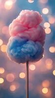 Colorful cotton candy treat on a stick with sparkling lights in the background at a fairground during an evening festival photo
