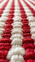 Textured woven rug with alternating red and white patterns showcasing intricate craftsmanship photo