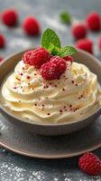 Delicious bowl of whipped cream topped with fresh raspberries and mint leaves against a textured backdrop photo