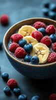 Healthy chia seed bowl topped with fresh berries and banana slices on a dark table photo