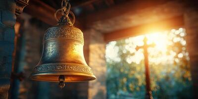 Golden bell hanging in a rustic setting with sunlight streaming through the window during late afternoon photo