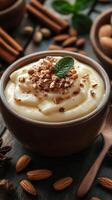 Delicious creamy dessert topped with chopped nuts and mint leaf on rustic wooden table photo