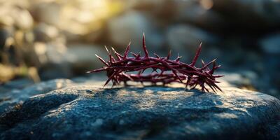 Representing sacrifice, a thorny crown lies on a stone in natural light during the golden hour at an outdoor location photo