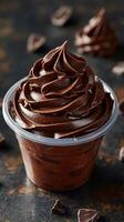 Chocolate mousse dessert in a clear cup with decorative swirls and chocolate shavings around it photo